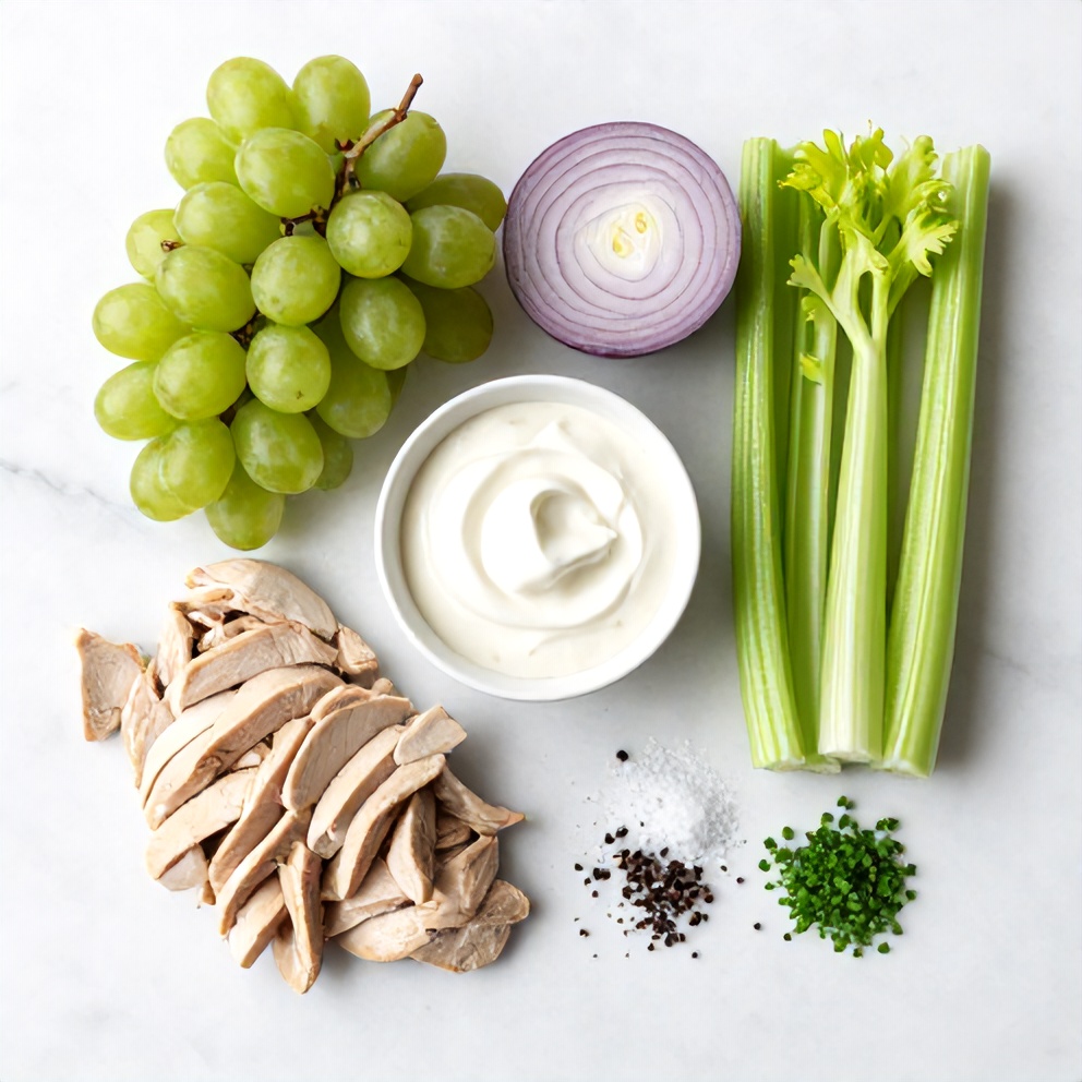 Raw ingredients for chicken grape salad: chicken, grapes, celery, onion, mayo, Greek yogurt, salt, pepper, and chives