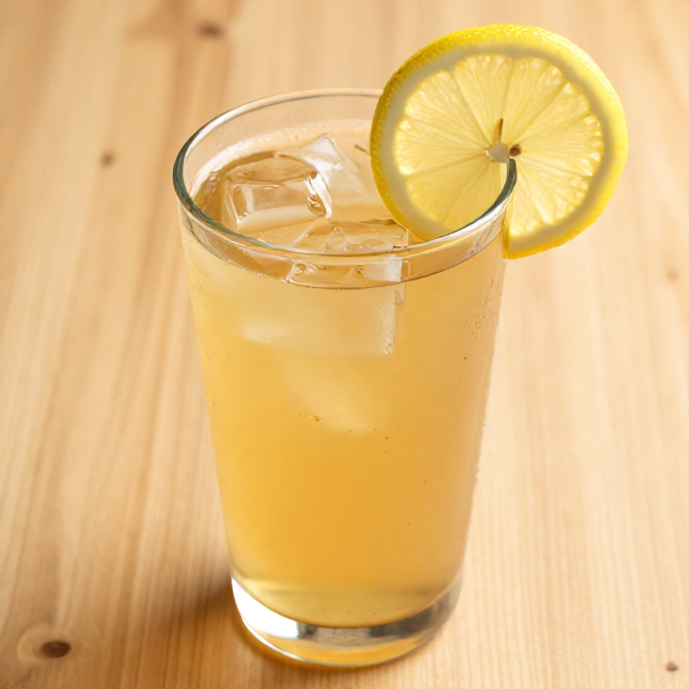 Guava White Tea Lemonade poured into a glass with a lemon slice garnish